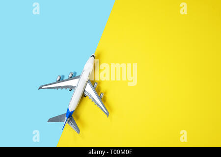 Modello di aeroplano piano o piano su giallo e blu sullo sfondo. Foto Stock