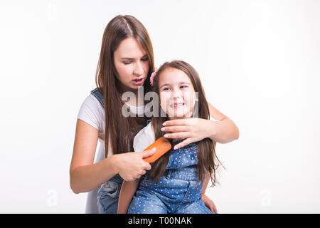 La famiglia, la maternità e il concetto di madre - madre la pettinatura la sua piccola figlia di capelli isolati su sfondo bianco Foto Stock