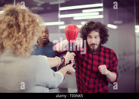 Multiethnics startup business team di sviluppatori di software divertimento mentre il pugilato a office,entusiasti diversi dipendenti ridere godendo di attività divertenti Foto Stock