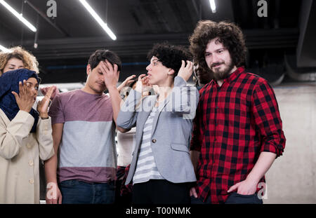 Ritratto di giovane eccitato multiethnics business team di sviluppatori di software in piedi e guardando la fotocamera mentre si celebra il successo all'avvio moderno Foto Stock