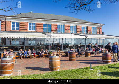 Le persone che si godono il sole in un cafe in Wilhelmshaven, Germania Foto Stock