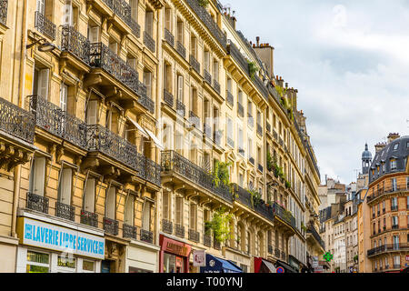 Via durante il mezzogiorno in Parigi, Francia. Giornata soleggiata con alcune nuvole e la luce diretta del sole. Foto Stock