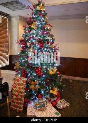 Albero di Natale con regali avvolti, splendidamente decorato e illuminato Foto Stock