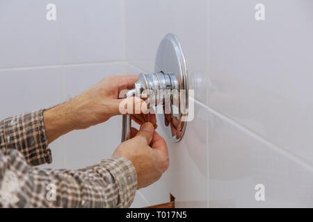 Plumber mani di fissaggio miscelatore doccia moderna tocca nel bagno di calore di controllo Foto Stock