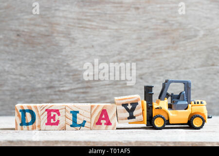 Toy carrello attesa blocco lettera y per completare la parola ritardo su uno sfondo di legno Foto Stock