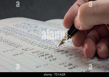 una scrittura a mano in un registro contabile d'epoca con una penna stilografica Foto Stock