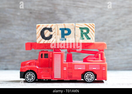 Giocattolo scala antincendio carrello attesa blocco lettera nella parola CPR (abbreviazione di rianimazione cardiopolmonare) su uno sfondo di legno Foto Stock