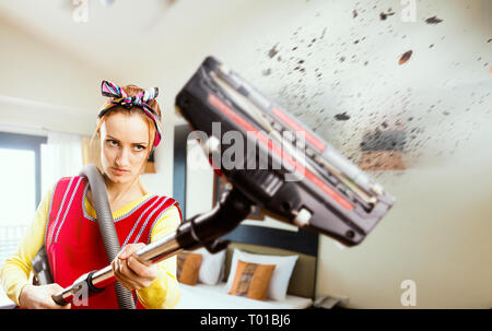 Arrabbiato casalinga nel grembiule con aspirapolvere Foto Stock