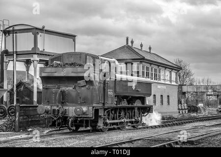 Bianco & Nero nostalgico vicino : vista posteriore del vintage locomotiva a vapore la manovra sul patrimonio via ferroviaria, Kidderminster SVR stazione mediante la casella segnale. Foto Stock