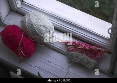 Due filati per maglieria e progetto accanto alla finestra. Foto Stock