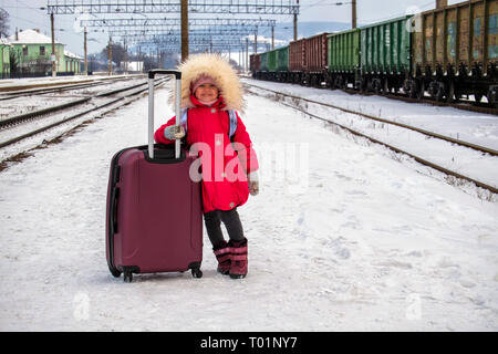 Felice bambina con il suo cane e la valigia in una stazione ferroviaria. il  capretto con cane in attesa del treno e felice circa il viaggio Foto stock  - Alamy