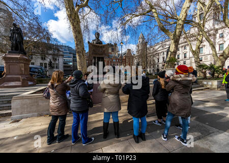 Un gruppo di donne a conoscere le opere di Millicent Fawcett, attivista per il suffragio femminile, in Piazza del Parlamento sul giorno del Commonwealth. Foto Stock