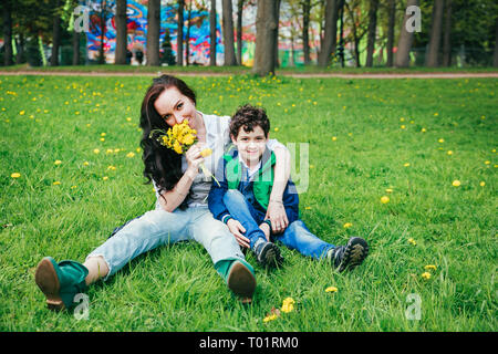 Carino allegro bambino con sua madre giocare all'aperto nel parco. Giorno Morthers Foto Stock