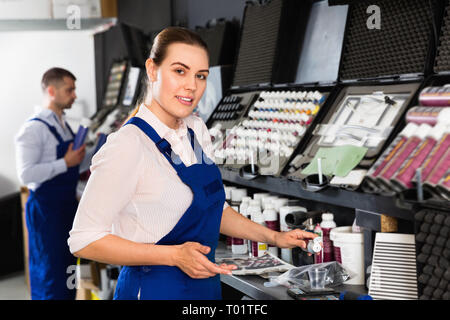 Positivo lieto femmina pittore auto preparazione delle vernici per verniciatura in moderno negozio di riparazioni auto Foto Stock