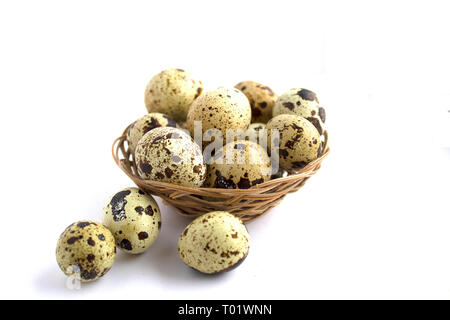 Uova di quaglia in un cesto su uno sfondo bianco. Uno stile di vita sano. Cucina dietetica Foto Stock