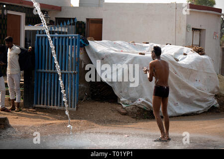 Un indiano l uomo si prende una doccia fuori di casa sua. Rajasthan, India. Foto Stock