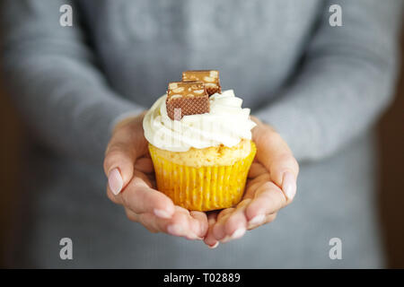 Deliziosa tortina con crema e caramelle nelle mani. Copia dello spazio. Concetto di cibo, dessert, panetteria, celebrazione, compleanno Foto Stock