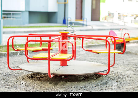 Giostra rosso sul parco giochi in città. Il concetto di infanzia, parenting, gioco Foto Stock