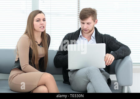 Azienda giovane seduto in ufficio e lavoro - parlando Foto Stock