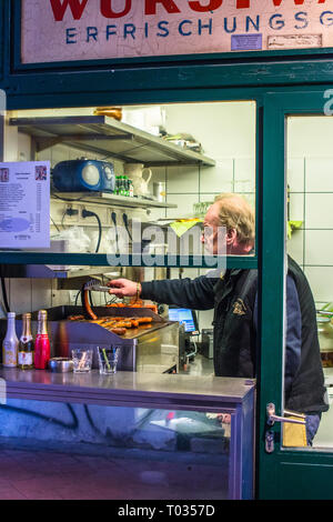 Locale salsicce bratwurst essendo teso su griglia di grandi dimensioni a Naschmarkt Linke Wienzeile mercato all'aperto. Austria. Foto Stock