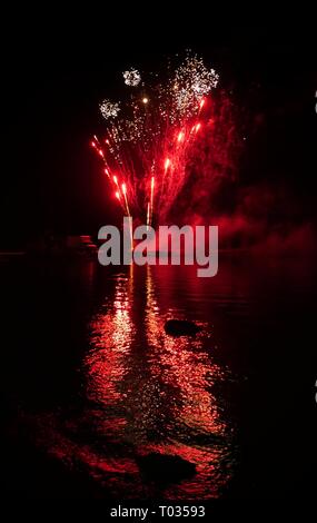 Modelli mozzafiato di fuochi d'artificio esplosione riflessi nell'acqua Foto Stock