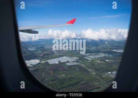 Guardando attraverso una finestra, volare un Avianca Airbus A320 che si affaccia sulla savana colombiano Foto Stock