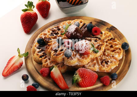 Waffle. Tradizionale cialde belghe con frutta fresca e zucchero in polvere sul pannello di legno Foto Stock