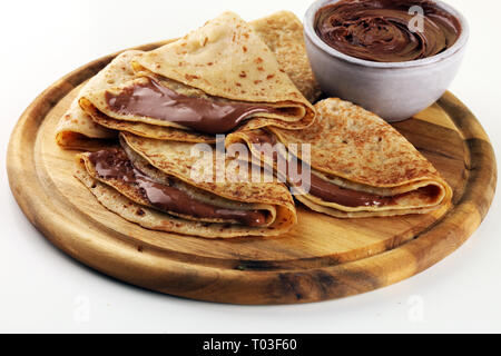 Deliziosi piatti gustosi crepes fatte in casa con cioccolato o frittelle su legno Foto Stock