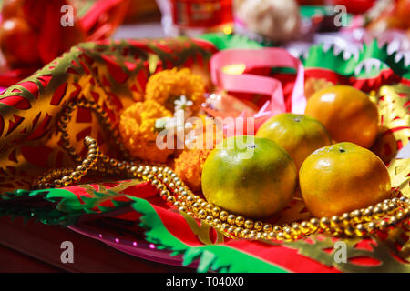 Frutta di arancia, Rosario, di fiori e di preghiera bandiera in Cinese Tempio Buddista, offerte di materiale tradizionale del Buddismo Mahayana pratiche devozionali per Foto Stock