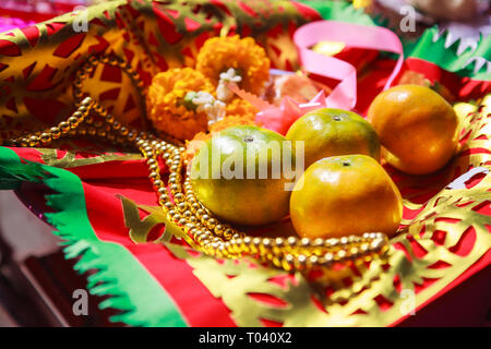 Frutta di arancia, Rosario, di fiori e di preghiera bandiera in Cinese Tempio Buddista, offerte di materiale tradizionale del Buddismo Mahayana pratiche devozionali per Foto Stock