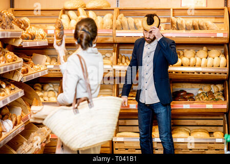 L uomo e la donna la scelta di pasticceria fresca nel reparto panetteria del supermercato Foto Stock