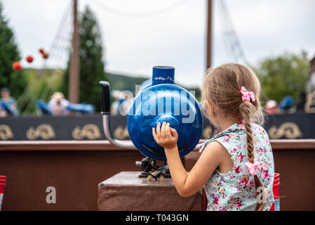 Loifling, Germania - 26 July, 2018: bambina gioca vicino al cannone giocattolo su Pirati dei Caraibi attrazione di Churpfalzpark Loifling. Il riposo e il divertimento per ev Foto Stock