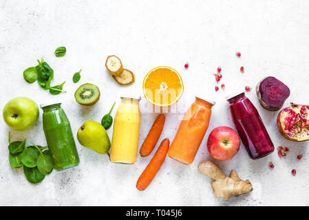 Vari i frullati o succhi di frutta in bottiglie e ingredienti su bianco, dieta sana materie detox vegan alimenti puliti concetto, vista dall'alto, copia dello spazio. Foto Stock