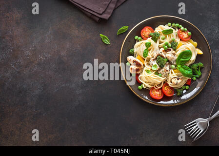 Il pollo e le verdure con la pasta. Spaghetti con grigliate di carne di pollo e verdure e basilico, vista dall'alto, copia dello spazio. Pasta di stagione primavera ricetta. Foto Stock