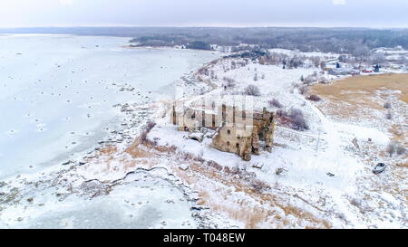 Vista panoramica del castello di Toolse in Estonia con un sacco di neve che circonda il piccolo castello in rovina e il mare ghiacciato su una stagione invernale Foto Stock