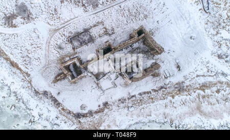 Oltre la vista superiore del vecchio castello Toolse essendo circondato con un sacco di neve sul terreno nel parco Lahemaa Foto Stock