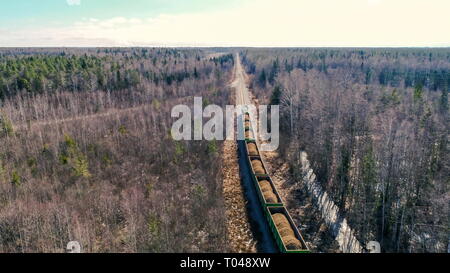 Riprese aeree di treni che circolano sulla railtracks con carri pieni di sabbia in una giornata di sole Foto Stock