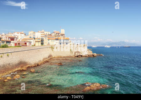 Le vecchie mura della città lungo la costa della cittadina francese di Antibes con il vecchio centro della distanza. Foto Stock