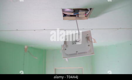 I fili bianchi all'interno del soffitto con la casella bianca appesa al foro quadrato del soffitto della casa Foto Stock