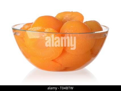 Pesche in scatola in una ciotola di vetro isolato su sfondo bianco Foto Stock