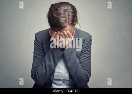 Business donna in tuta e camicetta coperto il viso con la sua mano. Lo stress e la stanchezza concetto di lavoro Foto Stock