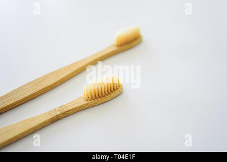 Due bambù spazzolini da denti di legno su sfondo grigio chiaro Foto Stock