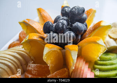 Frutta Mista in piastra bianca isolata su sfondo bianco - cibo sano stile Foto Stock
