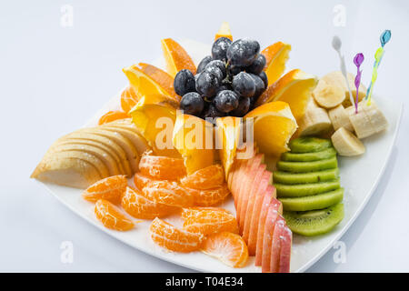 Frutta Mista in piastra bianca isolata su sfondo bianco - cibo sano stile Foto Stock