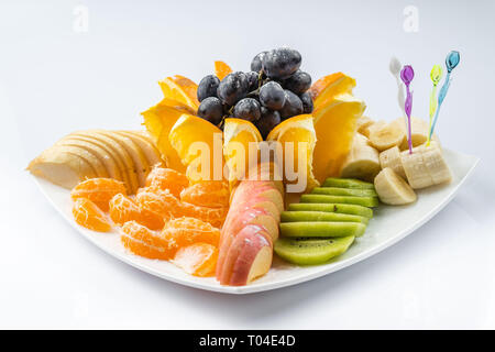 Frutta Mista in piastra bianca isolata su sfondo bianco - cibo sano stile Foto Stock