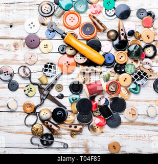 Rocchetti di fili e pulsanti sul tavolo in legno.Forbice, pulsanti di cucitura e filo Foto Stock