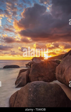 Gli ultimi raggi di sole creano una splendida atmosfera sulla spiaggia di Baie Lazare. Foto Stock