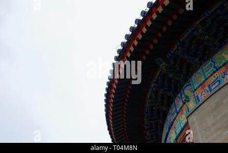 Dettaglio del tetto del tempio Cinese (il Tempio del cielo di Pechino). Ornato blu, rosso, verde e oro puntoni in piedi contro il cielo grigio Foto Stock