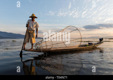 I pescatori pesca con grande net in tradizionale ed unico-gamba stile di voga durante il tramonto sul Lago Inle nello Stato di Shan, MYANMAR Birmania Foto Stock