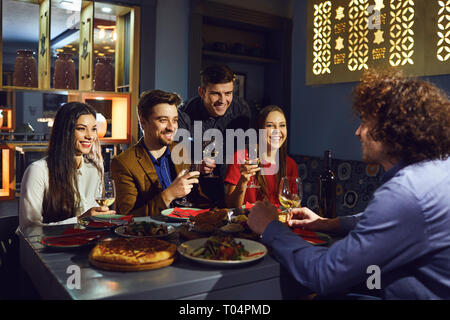 Amici parlare divertimento al tavolo nel ristorante Foto Stock